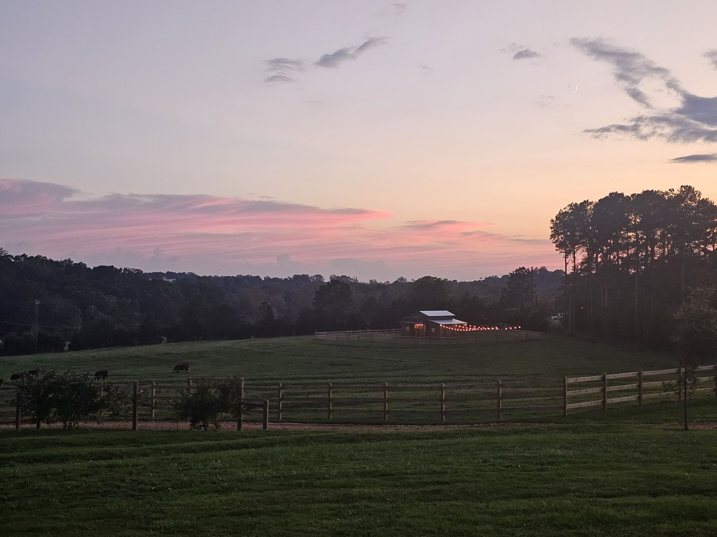 Sunset over the pastures and barn at Revolution Road Cattle Ranch in Central, South Carolina