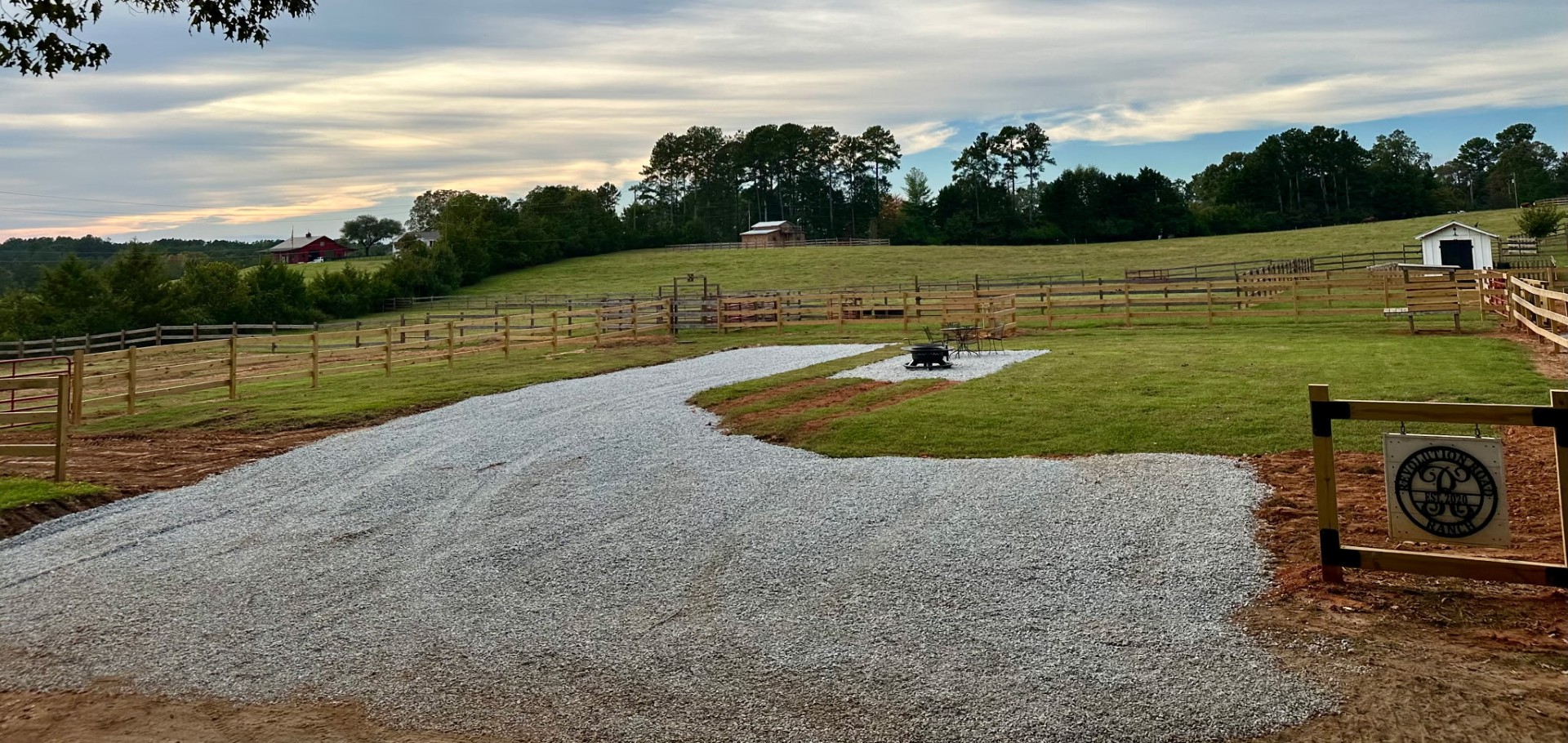 The RV site at Revolution Road Cattle Ranch with gravel pad, fire pit, and fenced pasture